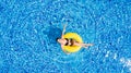 Aerial view of young brunette woman swimming on the inflatable big yellow in the pool. Top view of slim lady relaxing on her holid Royalty Free Stock Photo