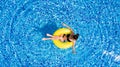 Aerial view of young brunette woman swimming on the inflatable big yellow in the pool. Top view of slim lady relaxing on her holid Royalty Free Stock Photo