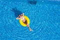 Aerial view of young woman swimming on the inflatable big yellow ring in pool Royalty Free Stock Photo