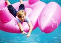 Aerial view of young caucasain boy floating in the pool with fla