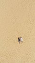 Aerial view of a young couple lying on the white sand. man and woman spend time together and travel through the desert Royalty Free Stock Photo