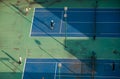 Aerial view of young people playing tennis on a winter afternoon Royalty Free Stock Photo