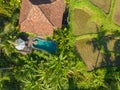 Aerial view of a young woman having breakfast on a floating basket in a pool