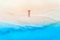 Aerial view of the young woman lying on the white sandy beach