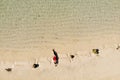 Aerial view of young woman in red bikini lying on beach with white sand, foaming waves of the Indian Ocean. Bali Island, Indonesia