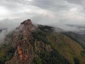 Aerial viw of fog among the mountain peaks. Bad weather and fog in the Siberian nature reserve Stolby.