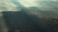 Aerial vulcanic desert landscape with rays of light