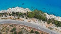 Aerial. White car motion by the mediterranean asphalt road. Vehicle driving with beautiful sea landscape. Top view