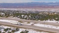 AERIAL: White truck hauls cargo down scenic freeway running across snowy desert