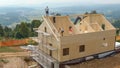 AERIAL: Workers begin to assemble the roof of a prefabricated hardwood house.