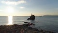 Aerial for wrecked ship along the rocky coast against shining sun. Shot. Old sunk boat near sea shore on big mountain Royalty Free Stock Photo