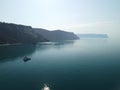 Aerial yacht on calm sea. Luxury cruise trip. View from above of white boat on deep blue water. Aerial top down view of