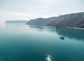 Aerial yacht on calm sea. Luxury cruise trip. View from above of white boat on deep blue water. Aerial view of rich