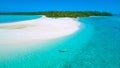 AERIAL: Young woman relaxing in the glassy ocean water by the lush exotic island