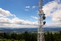 Aerials and transmitters on telecommunication tower with mountains in background Royalty Free Stock Photo