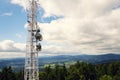 Aerials and transmitters on telecommunication tower with mountains in background Royalty Free Stock Photo