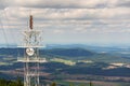 Aerials and transmitters on telecommunication tower with mountains in background Royalty Free Stock Photo