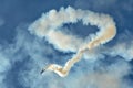 Aerobatic airplane performing on the blue sky, big trace of smoke