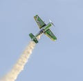 Aerobatic airplane pilot Jurgis Kairys training in the sky of the city. Colored airplane with trace smoke, airbandits, aeroshow