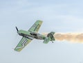 Aerobatic airplane pilot Jurgis Kairys training in the sky of the city. Colored airplane with trace smoke, airbandits, aeroshow