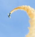 Aerobatic airplane pilot Jurgis Kairys training in the sky of the city. Colored airplane with trace smoke, airbandits, aeroshow