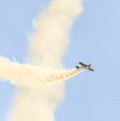 Aerobatic airplane pilot Jurgis Kairys training in the sky of the city. Colored airplane with trace smoke, airbandits, aeroshow