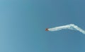 Aerobatic plane leaving a white smoke trail in the blue sky. Royalty Free Stock Photo