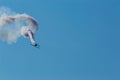 Aerobatic plane leaving a white smoke trail in the blue sky. Royalty Free Stock Photo