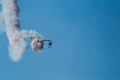 Aerobatic plane leaving a white smoke trail in the blue sky. Royalty Free Stock Photo