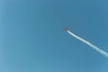 Aerobatic plane leaving a white smoke trail in the blue sky. Royalty Free Stock Photo