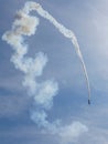 Aerobatic plane performing a multiple corkscrew maneuver leaving a smoke trail