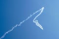 Aerobatic plane performing a multiple corkscrew maneuver leaving a smoke trail