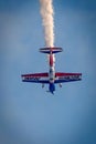 Aerobatic plane with smoke trail in blue sky. Royalty Free Stock Photo