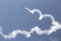 Aerobatic plane with a white smoke trail in sky. Royalty Free Stock Photo
