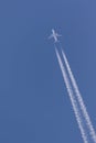 Aeroplane in the clear blue sky leaving vapor trails behind Royalty Free Stock Photo