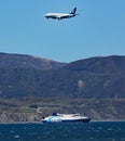 Aeroplane on final approach to Wellington airport, passes over an Interislander ferry on it`s way to South Island on the Cook