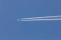 Aeroplane flying through clear blue sky with vapour trails Royalty Free Stock Photo