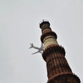 Aeroplane flying in the cloudy sky during the day time near Qutub Minar in Delhi India, Aeroplane flying high in the sky