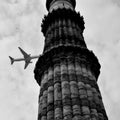 Aeroplane flying in the cloudy sky during the day time near Qutub Minar in Delhi India, Aeroplane flying high in the sky