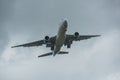 An aeroplane flying by during landing under cloudy storm