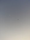 An aeroplane in the sky along side the moon