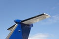 Aeroplane wing tale viewed from below with blue sky Royalty Free Stock Photo