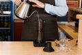 Aeropress coffee alternative making by barista in the cafe. Scandinavian coffee brewing method. Barista pours water to