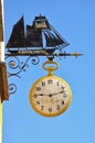 Aeroskobing, Denmark - July 4th, 2012 - Metal store sign of an antique shop shaped like a sailing ship with vintage clock undernea