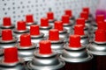Aerosol cans with a bright red lid are in a row. Macro photo. Selective focus on the nozzle. paint Royalty Free Stock Photo