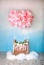 Aerostat from balloons with basket decorated with flowers. Balloons basket for air flight on background decorative blue sky with c Royalty Free Stock Photo