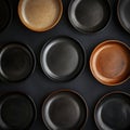 Aesthetic Arrangement of Elegant Dark Ceramic Plates with Unique Patterns on a Textured Surface Showing Different Shapes and Royalty Free Stock Photo