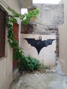 Aesthetic Batman logo on a wall with plantation