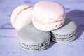 Aesthetic blurred photo with special filter. Lavender light color macarons on wooden background. French Pastel Macaroons