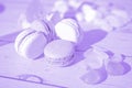 Aesthetic blurred photo with special filter. Lavender light color macarons on wooden background. French Pastel Macaroons.